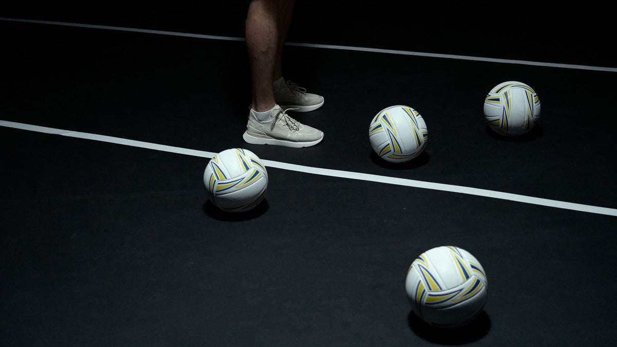 Volleyballs on a dark indoor court