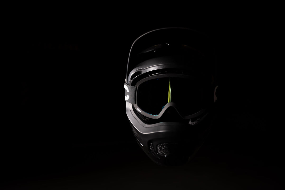 Protective helmet and goggles emerging from darkness