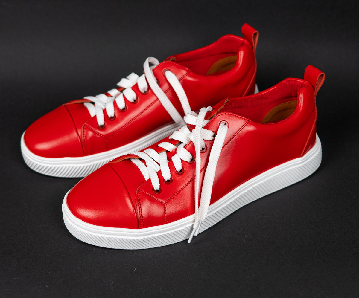 New red sneakers on a black studio background