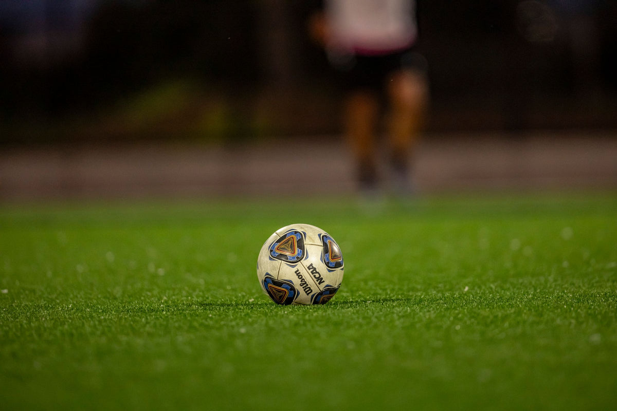 Football on a floodlit pitch at night