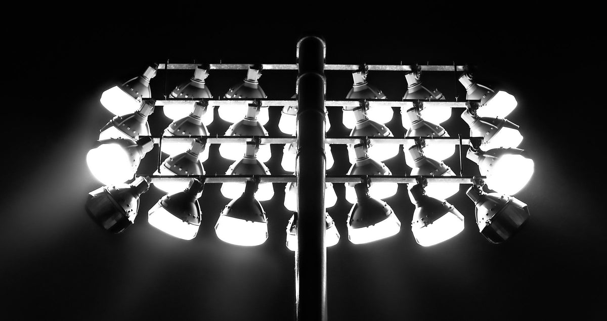 Stadium floodlights glowing against a black night sky