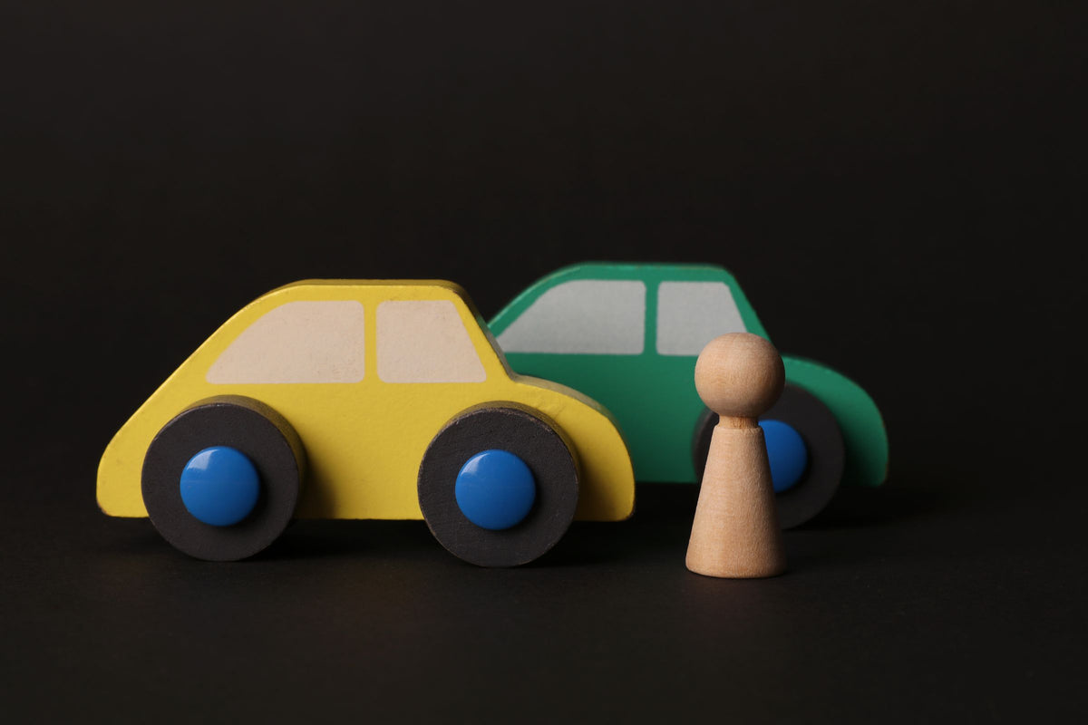Colourful wooden toy cars on a black background