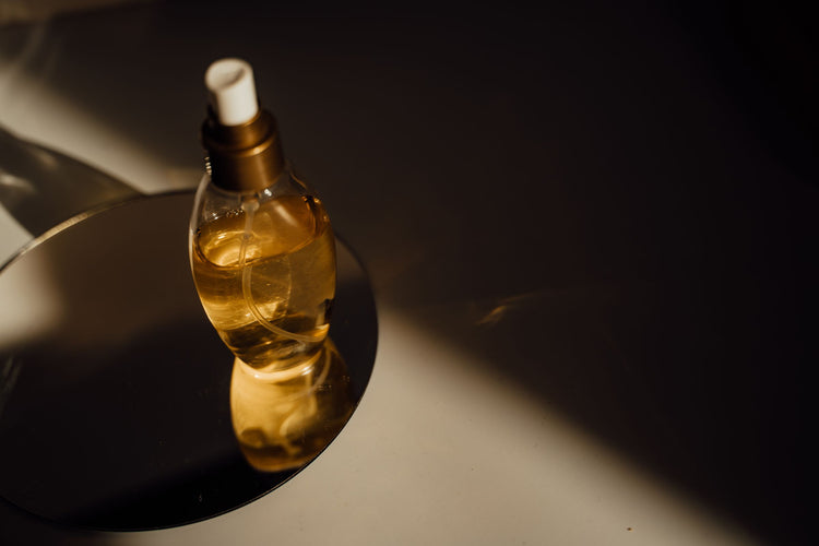 Unlabelled amber perfume bottle in a beam of warm light